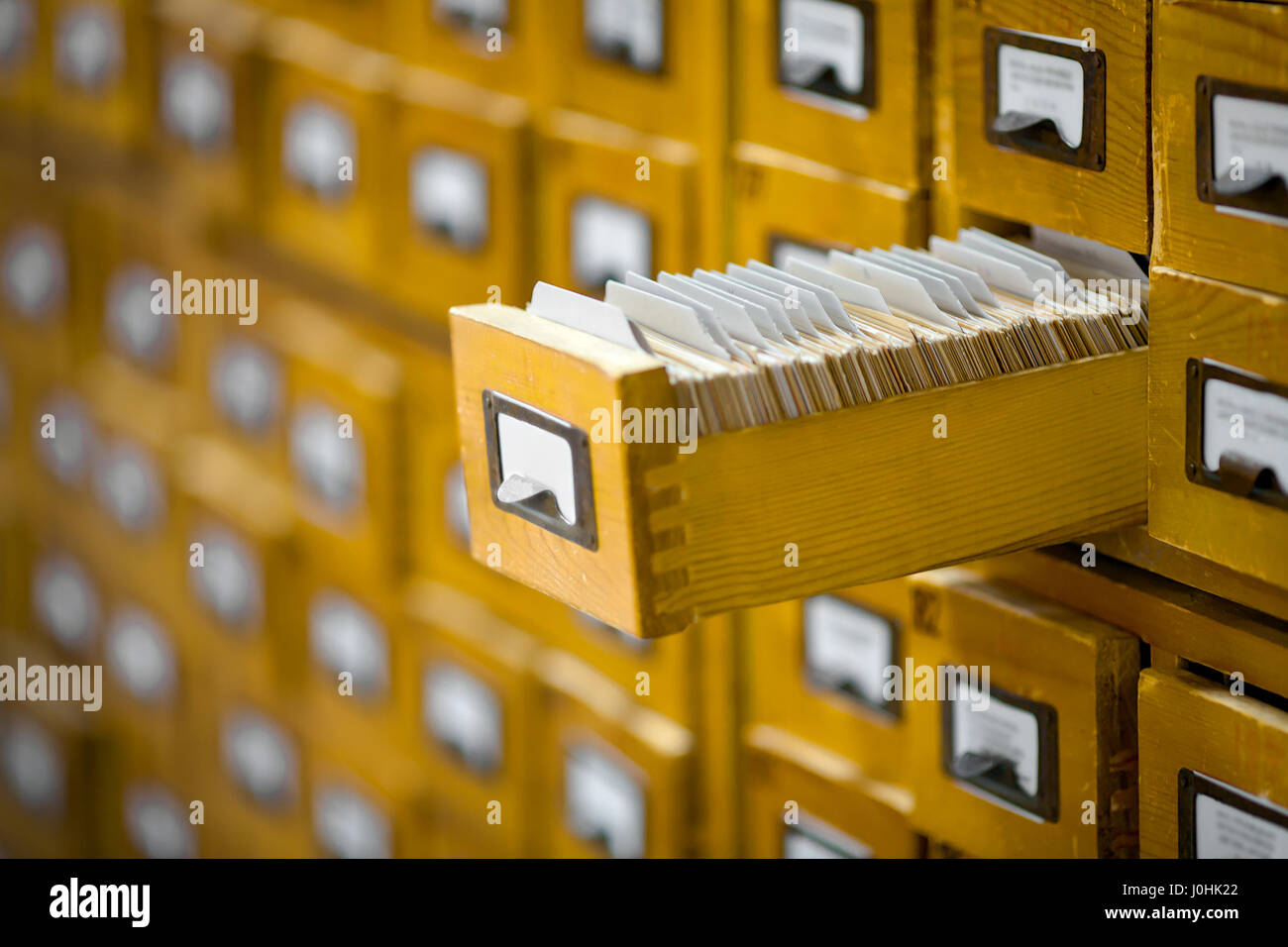 yellow library or archive reference catalogue with opened card drawer. Stock Photo