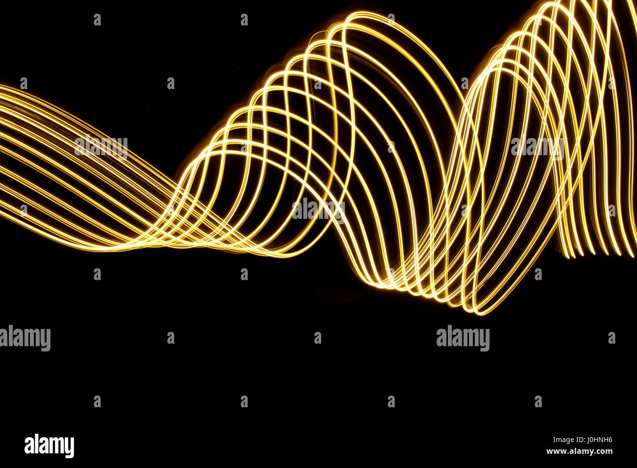Gold light painting photography, swirls against a black background ...