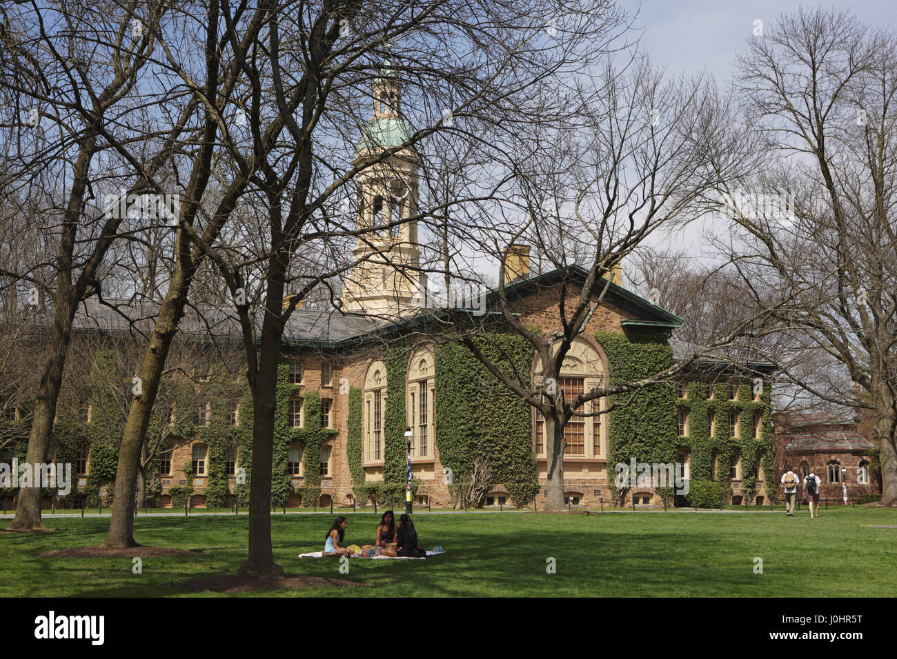 Princeton, NJ, USA - April 11, 2017: Princeton University Campus in spring. Nassau Hall and Cannon Green. Students sitting on the lawn on a sunny day. Stock Photo
