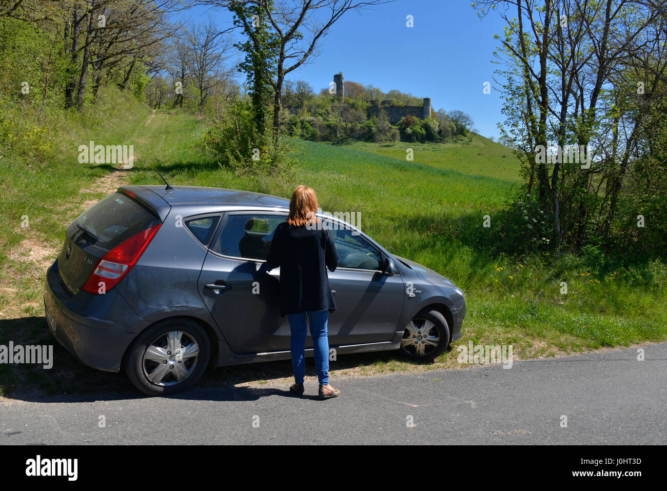 Tourist and car at the overgrown ruins of Combefa Castle, near Monesties, Occitanie, France. Stock Photo