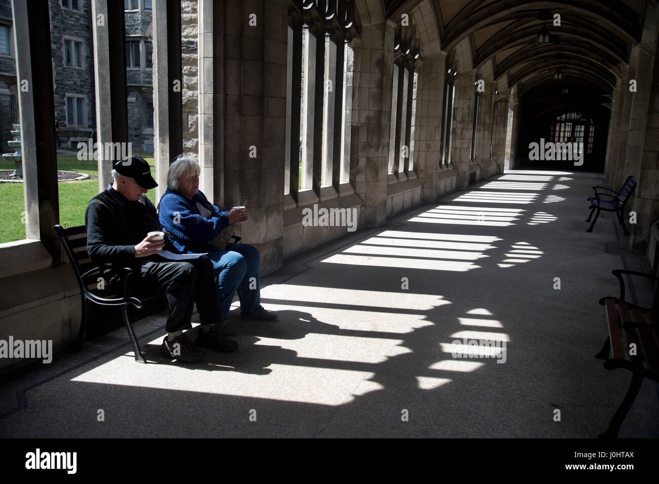 Canada, Toronto. University of Toronto, Hart College. Two older people take a rest in the sun. Stock Photo