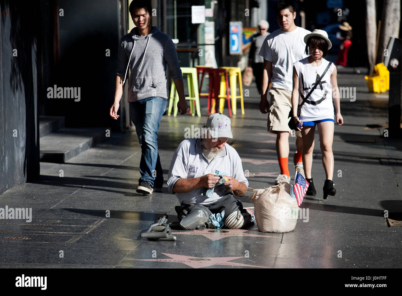 A homeless man burnishes the stars on the Hollywood walk of Fame Stock Photo