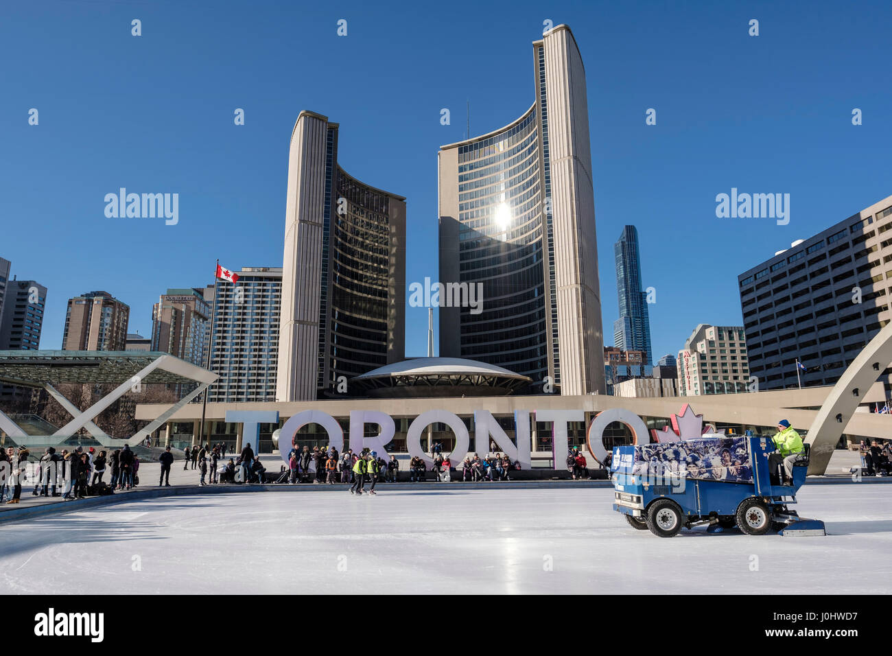Toronto City Hall, Nathan Phillips Square in winter, zamboni grooming ice skating rink, Toronto sign, people in downtown Toronto, Ontario, Canada. Stock Photo