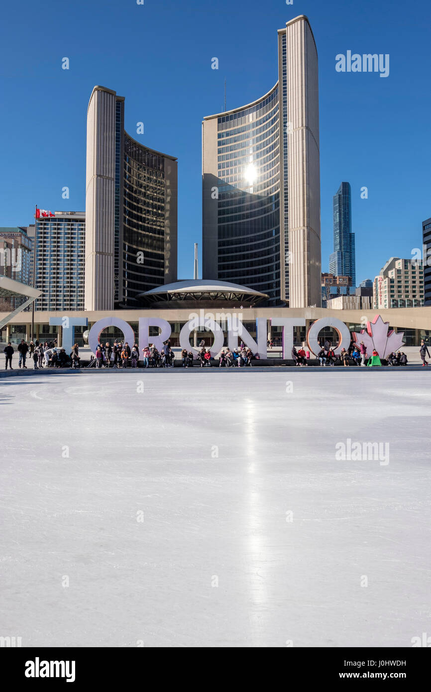 Toronto City Hall, Nathan Phillips Square in winter, ice skating rink, Toronto sign, people in downtown Toronto, Ontario, Canada. Stock Photo