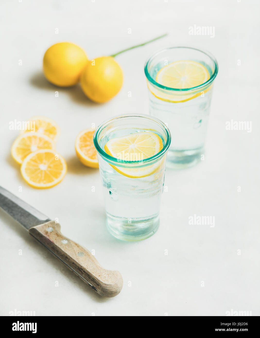 Morning detox lemon water in glasses and fresh lemons Stock Photo