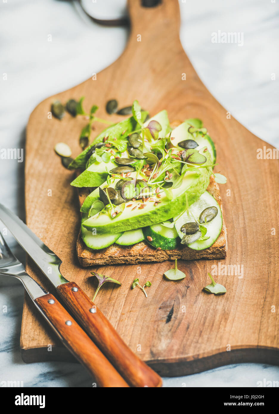 Healthy green veggie sandwich with avocado on board Stock Photo Alamy