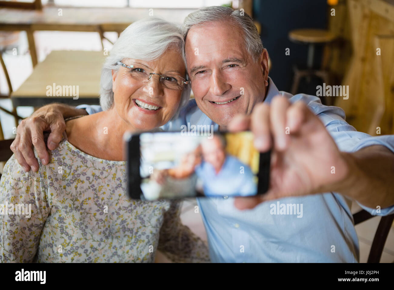 Happy senior couple taking selfie on mobile phone in cafÃƒÂ© Stock ...