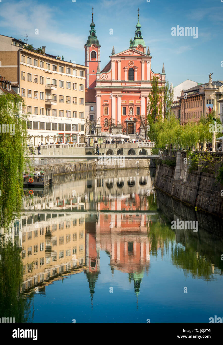 Ljubljana Old Town by Day. The river creates a beautiful reflection of the Franciscan Church Stock Photo