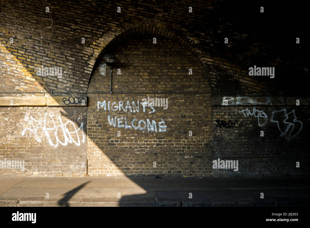 Graffiti in Londons Bethnal Green welcoming migrants. Stock Photo