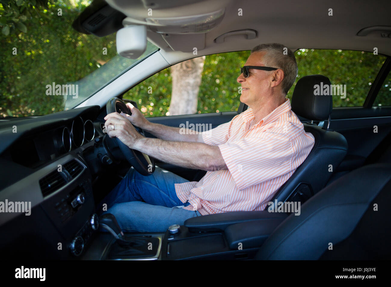 Senior man wearing sunglasses while driving car Stock Photo Alamy