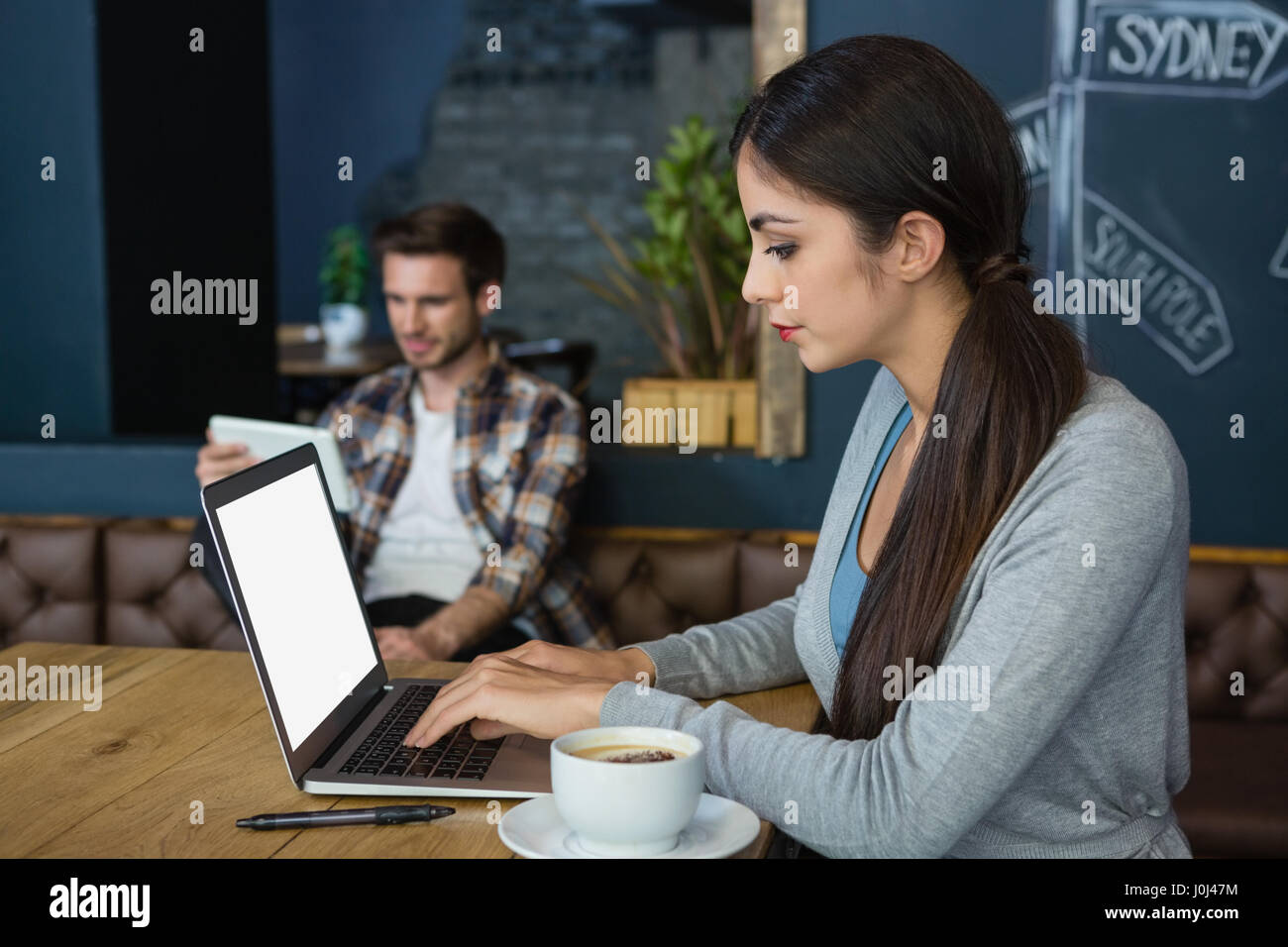 Young woman using laptop while having coffee in cafÃƒÂ© Stock Photo - Alamy