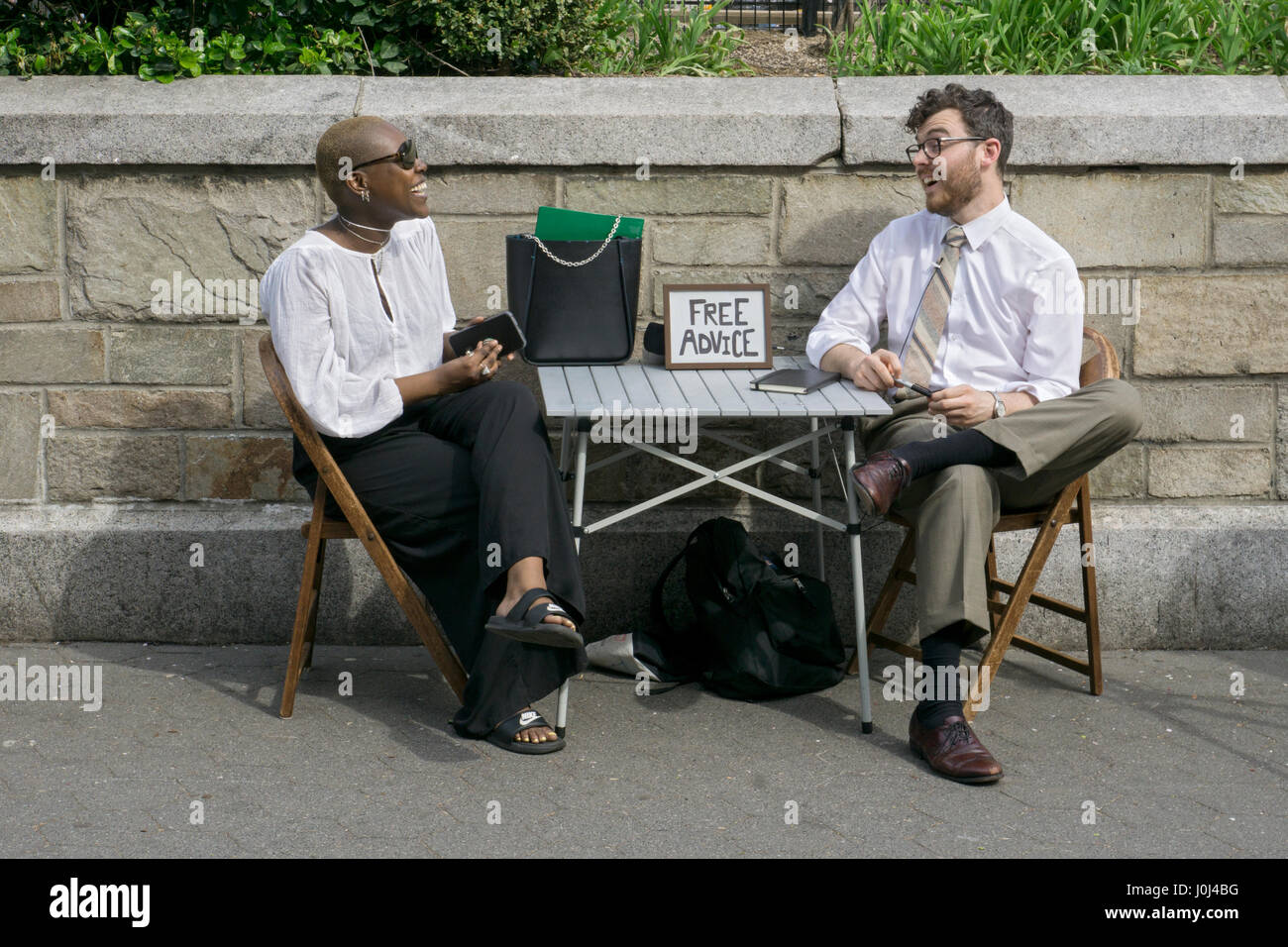 A young man giving free advice to a woman in Union Square Park in Manhattan, New York City. Stock Photo