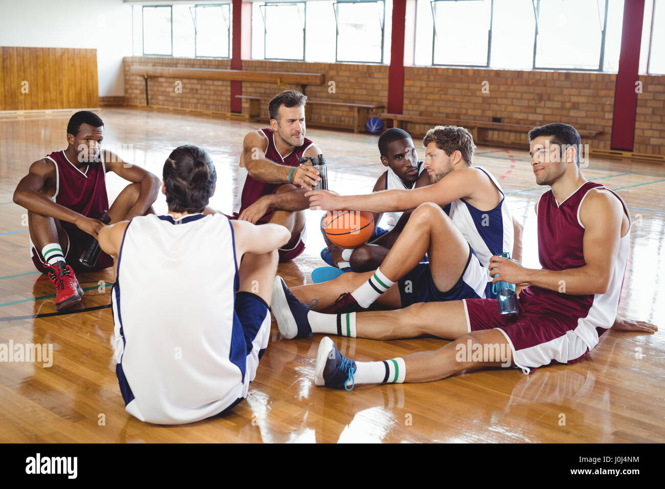 Basketball players interacting while relaxing in the court Stock Photo Alamy