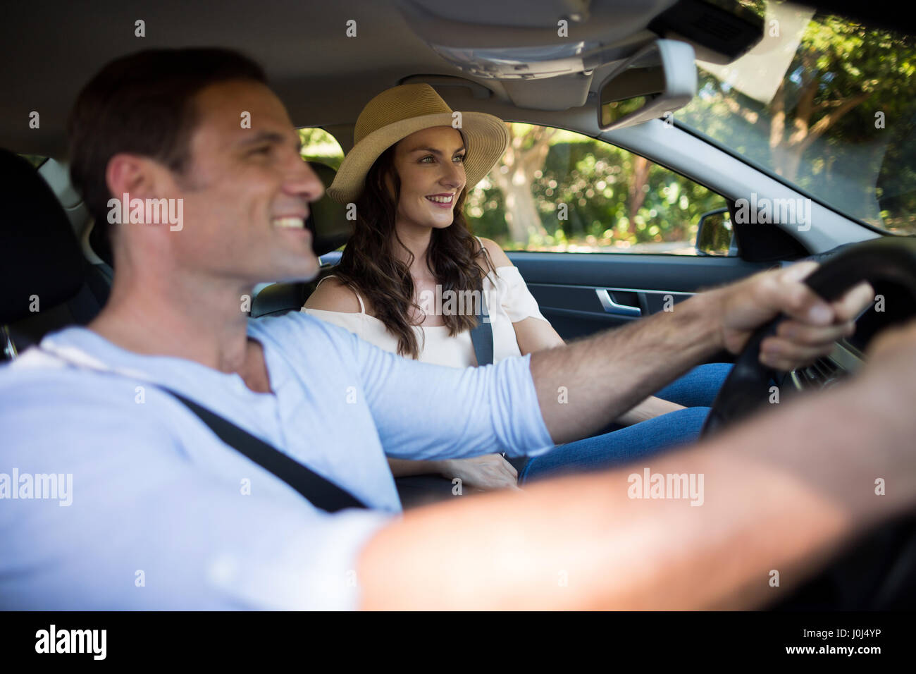 Smiling young couple sitting car Stock Photo - Alamy