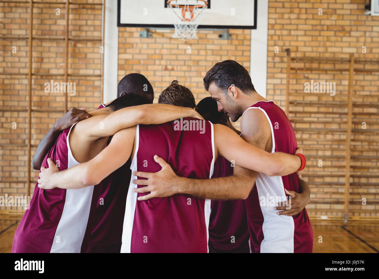 Basketball players forming a huddle in the court Stock Photo Alamy