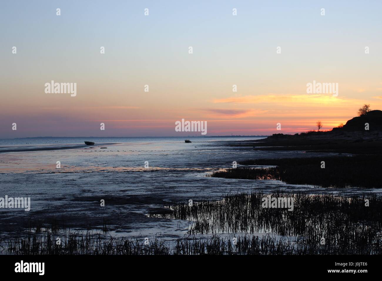 Calm sea, fishing boats at sunset reflections Stock Photo - Alamy