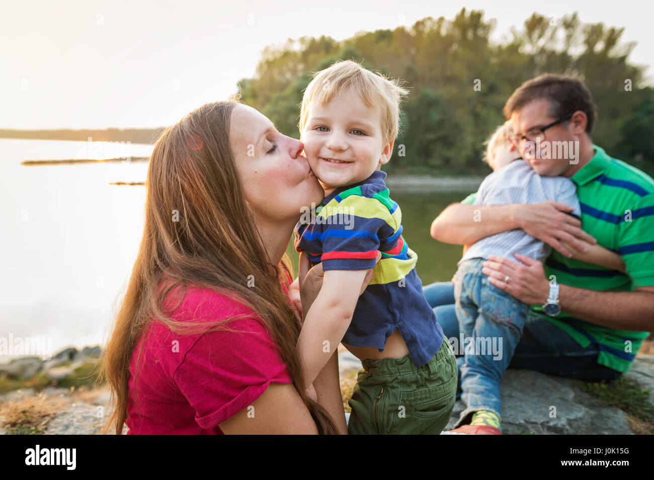 Family with two boys at the lake, sunny spring day. Stock Photo