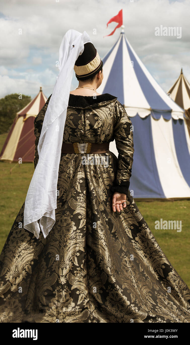 Medieval woman in costume overlooking tents Stock Photo