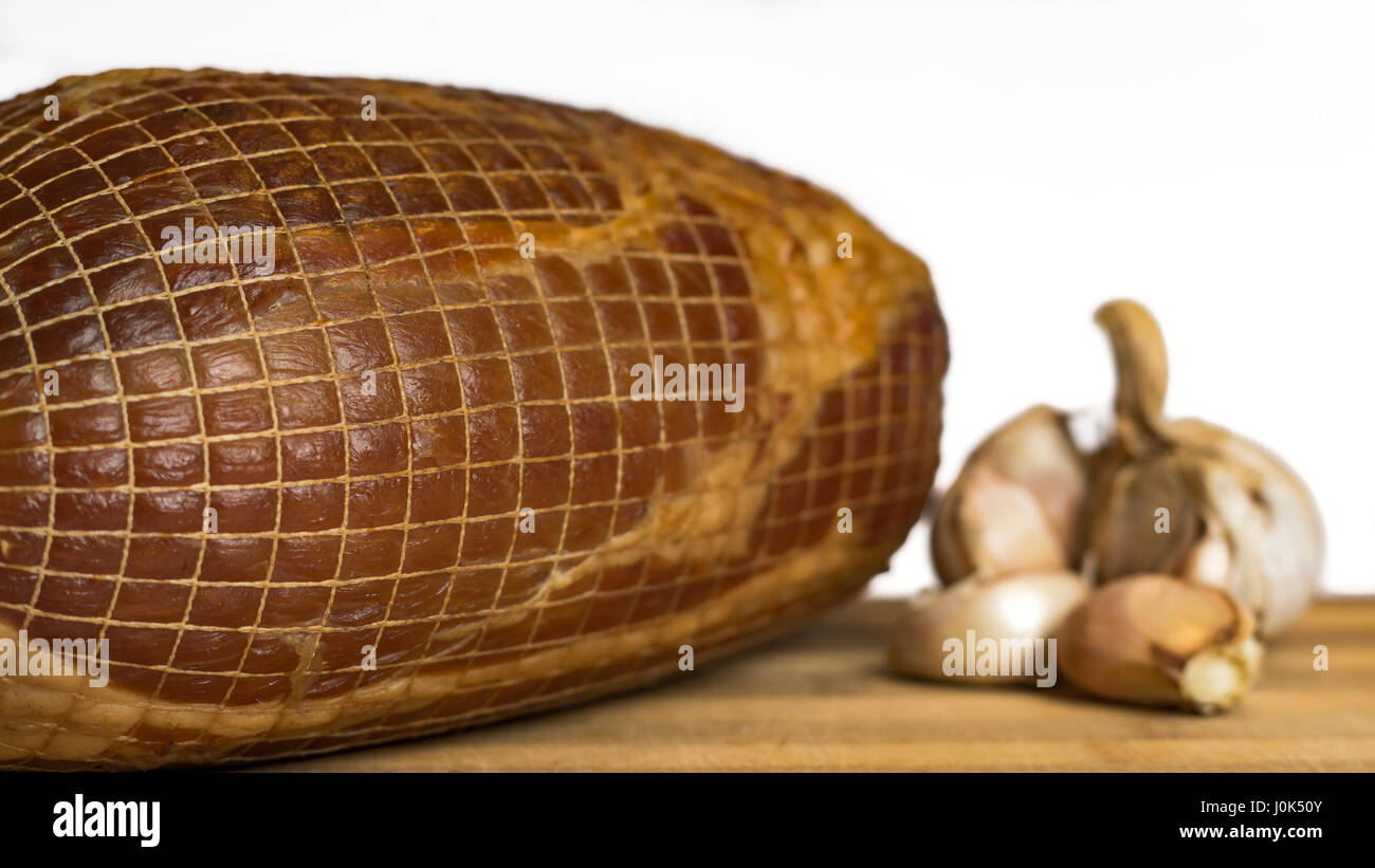 Piece of hungarian smoked and tied ham in front of white background ...