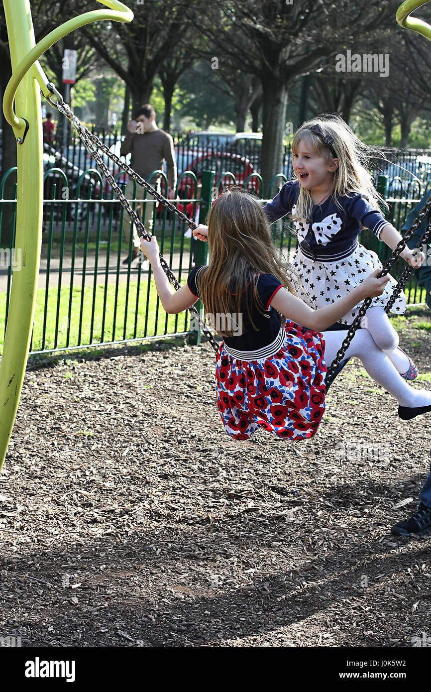 Children, kids having great fun playing on the swing, swings in the