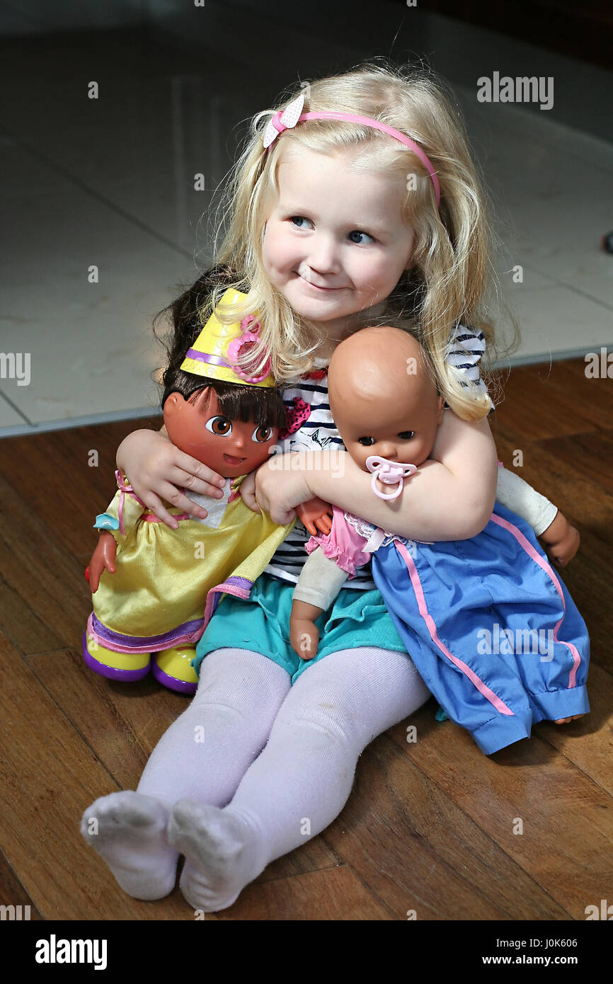 Little blonde girl, child playing with her dolls, Dora the explorer, Annabel, children toys, kid toys Stock Photo