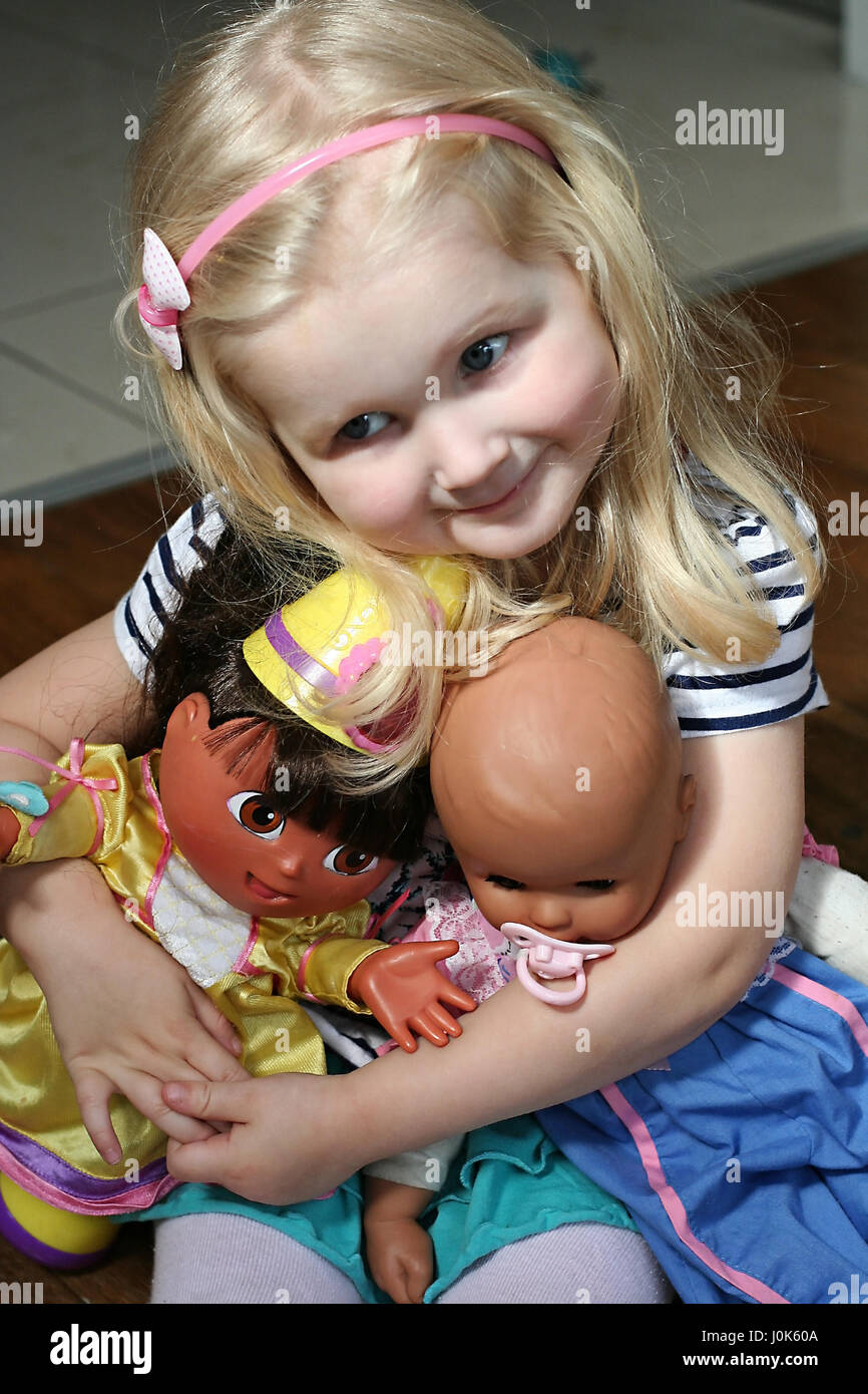 Little blonde girl, child playing with her dolls, Dora the explorer, Annabel, children toys, kid toys Stock Photo