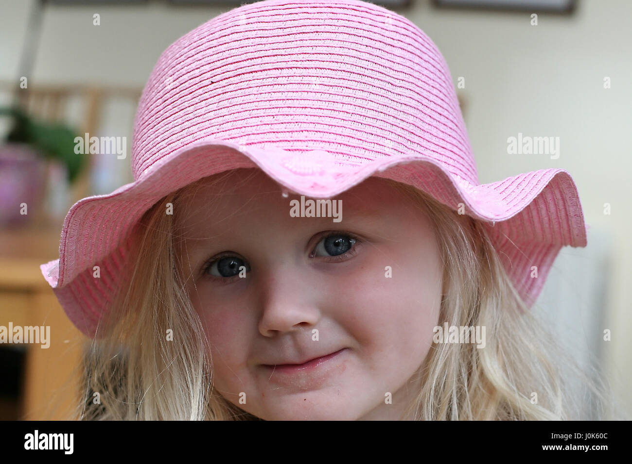 Closeup of a Child, little blonde girl wearing a straw easter