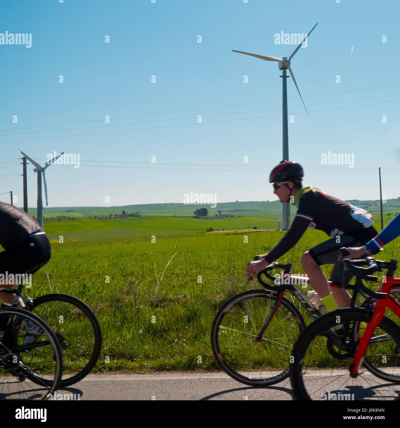 Group of ciclysts and wind energy to background. Stock Photo