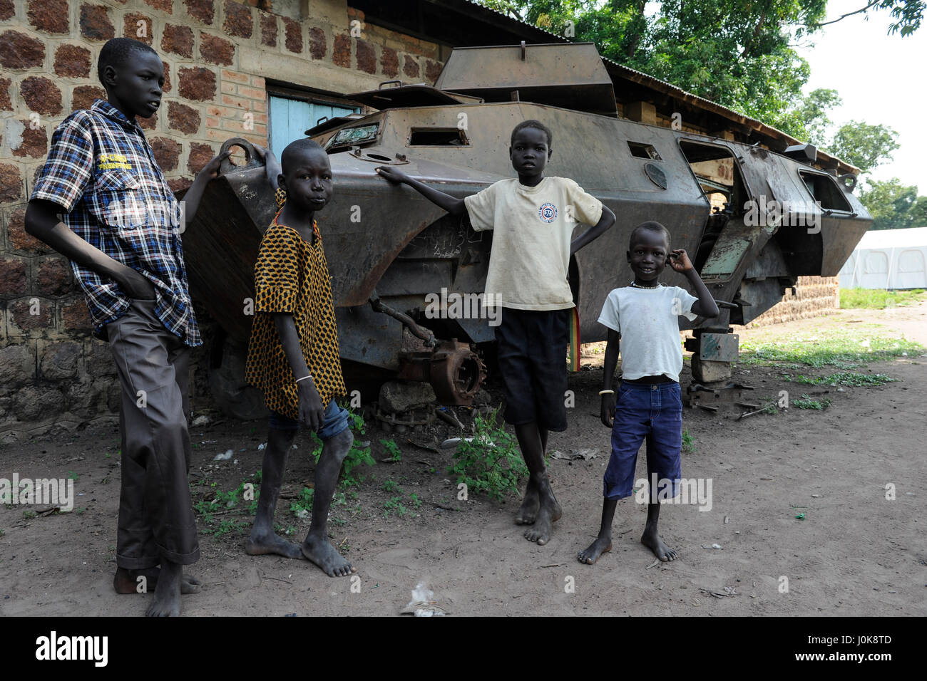 SOUTH SUDAN, Lakes State, town Rumbek, abandoned wreck of armoured personnel wagon Cadillac Gage V-150 Commando, Made in USA, from second sudanese civil war between south sudanese peoples liberation army SPLA and Sudanese Armed Forces SAF at former SAF barracks, children, young boys Stock Photo