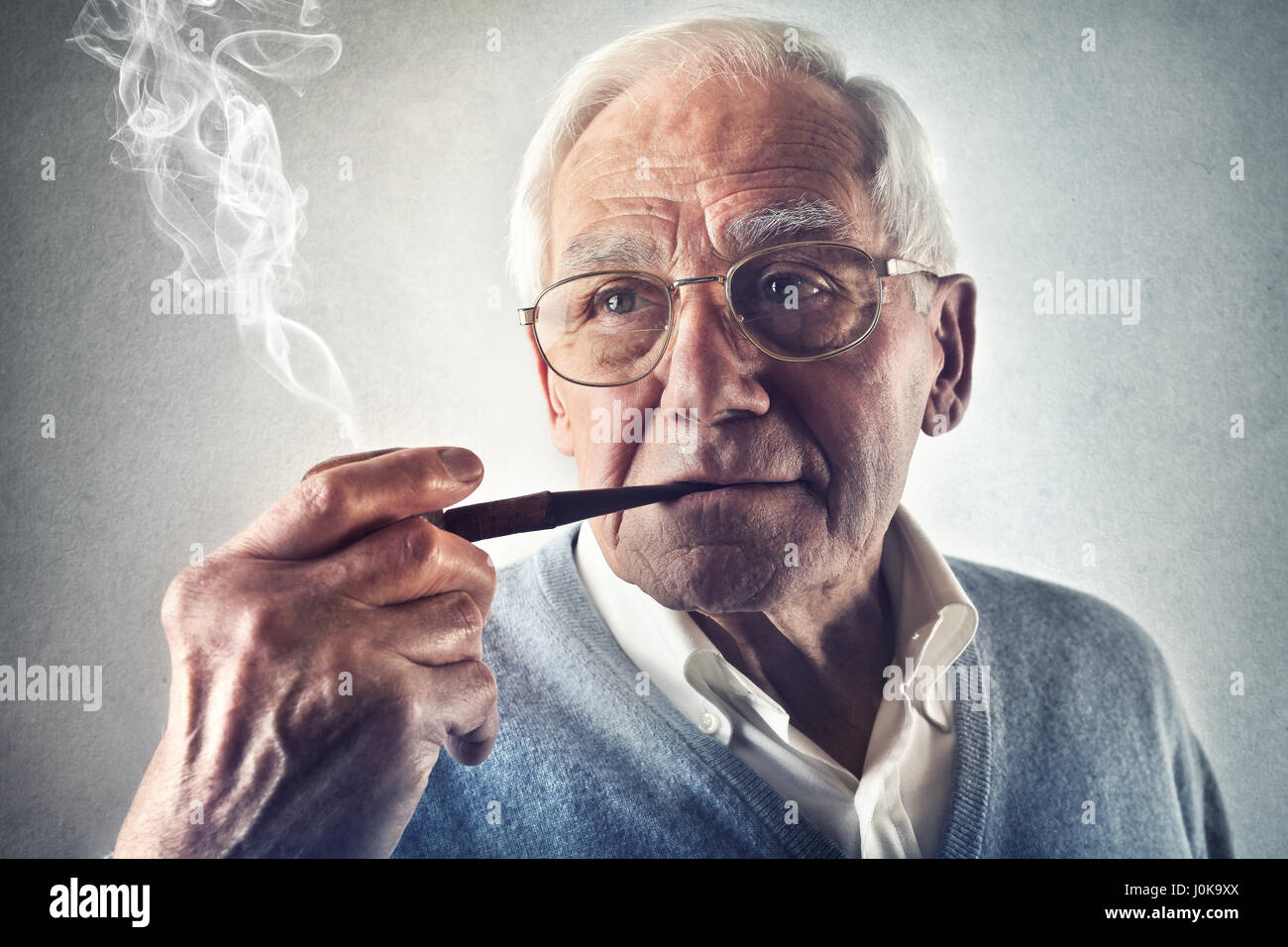 Old man smoking pipe Stock Photo