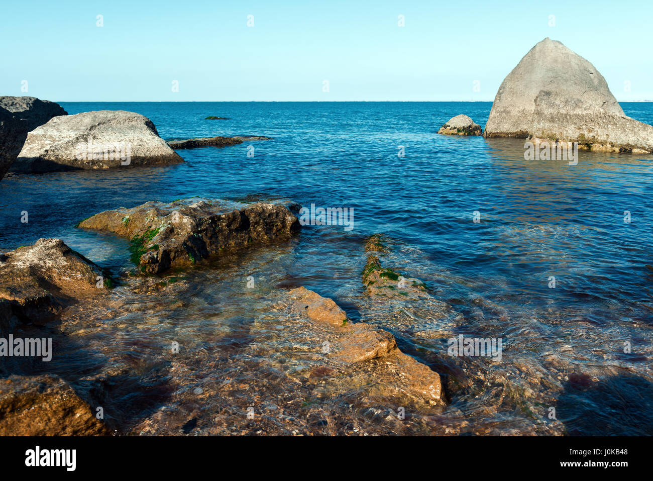 Coast with rocks and blue water Stock Photo - Alamy