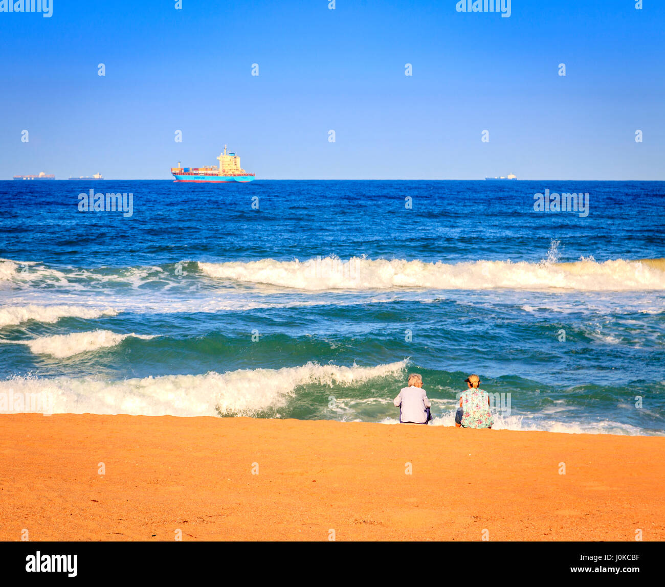 Two women are enjoying sunny evening on the beach in Durban, South Africa Stock Photo