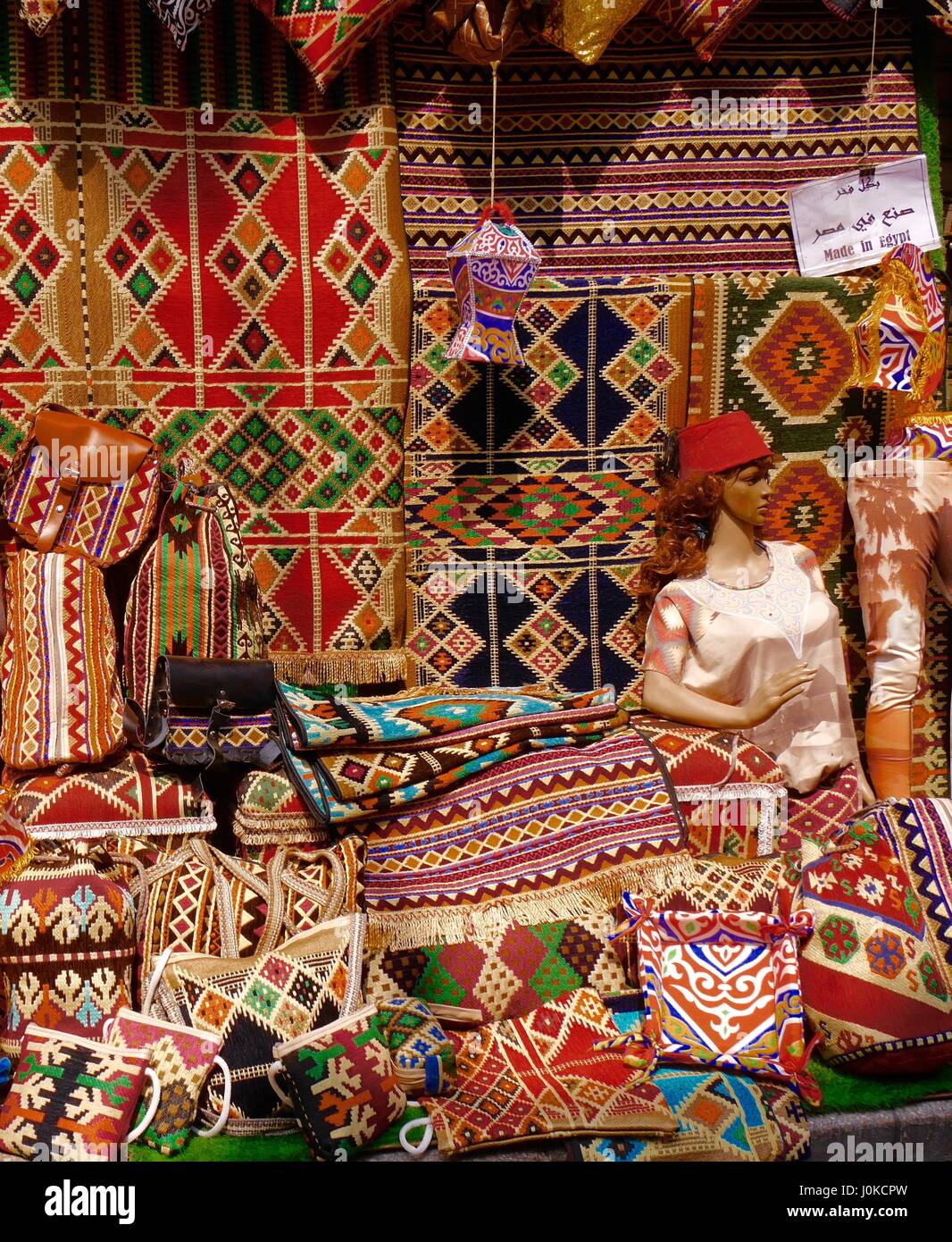 Varied display of traditional richly patterned carpets, rugs, cushion-covers, other textile souvenirs on sale in Khan al-Khalili bazaar, Cairo, Egypt Stock Photo