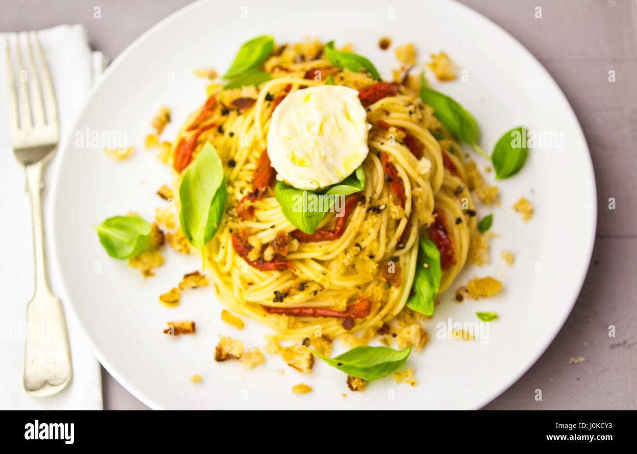 Spaghetti with sun dried tomatoes basil mozzarella Stock Photo Alamy