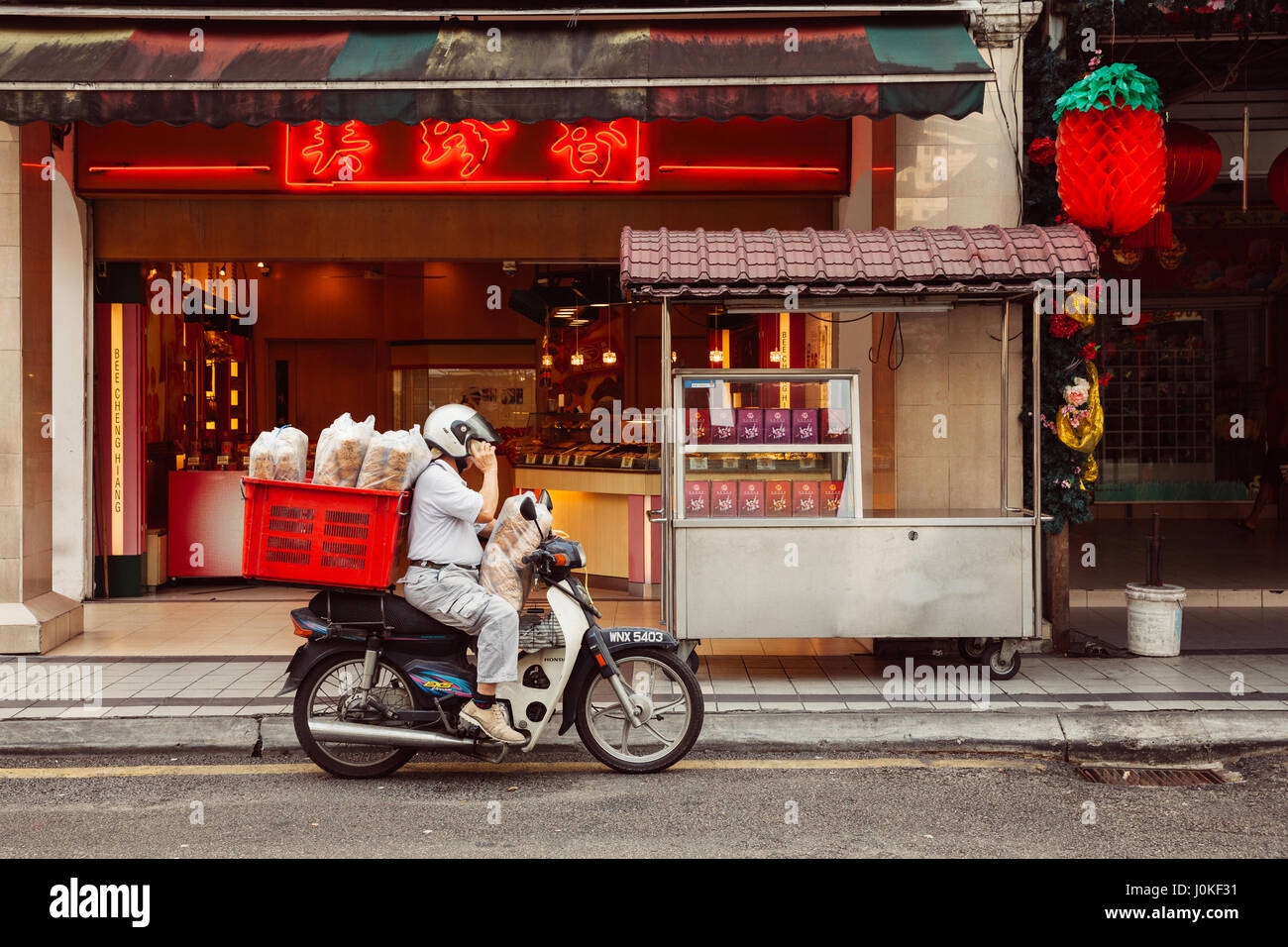 Kuala Lumpur, Malaysia - March 17, 2016:  Man delivering supplies to Chinese restaurant in Chinatown, Kuala Lumpur, Malaysia on March 17, 2016. Stock Photo