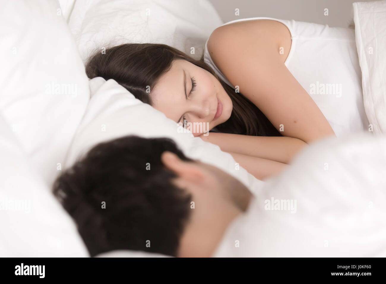 Young lovely beautiful couple sleeping comfortably in bed, close Stock Photo