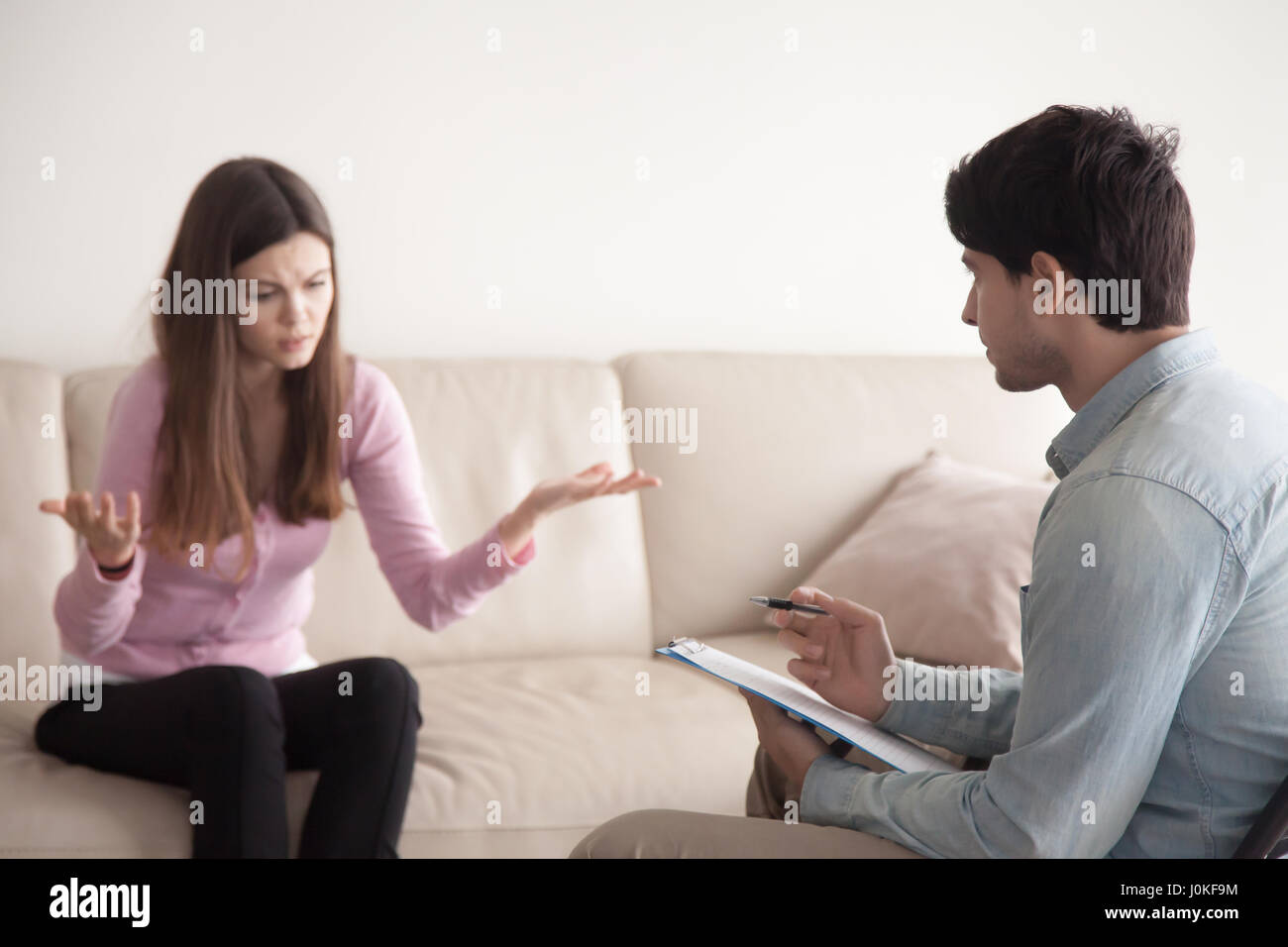 Conversation between male psychologist and young female patient, Stock Photo