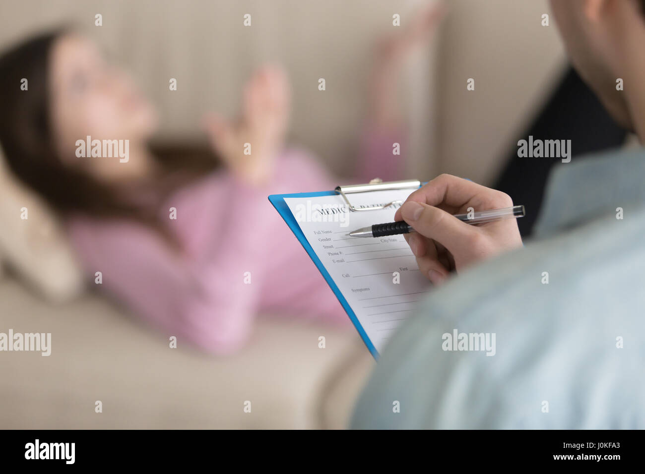 Male psychologist filling information about female patient in me Stock Photo