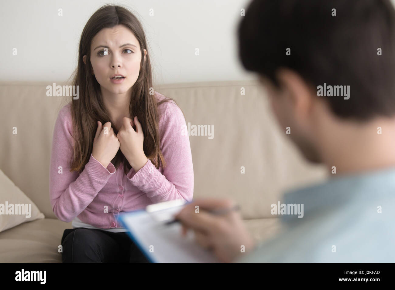 Young sad woman telling about her problem to male psychotherapis Stock Photo