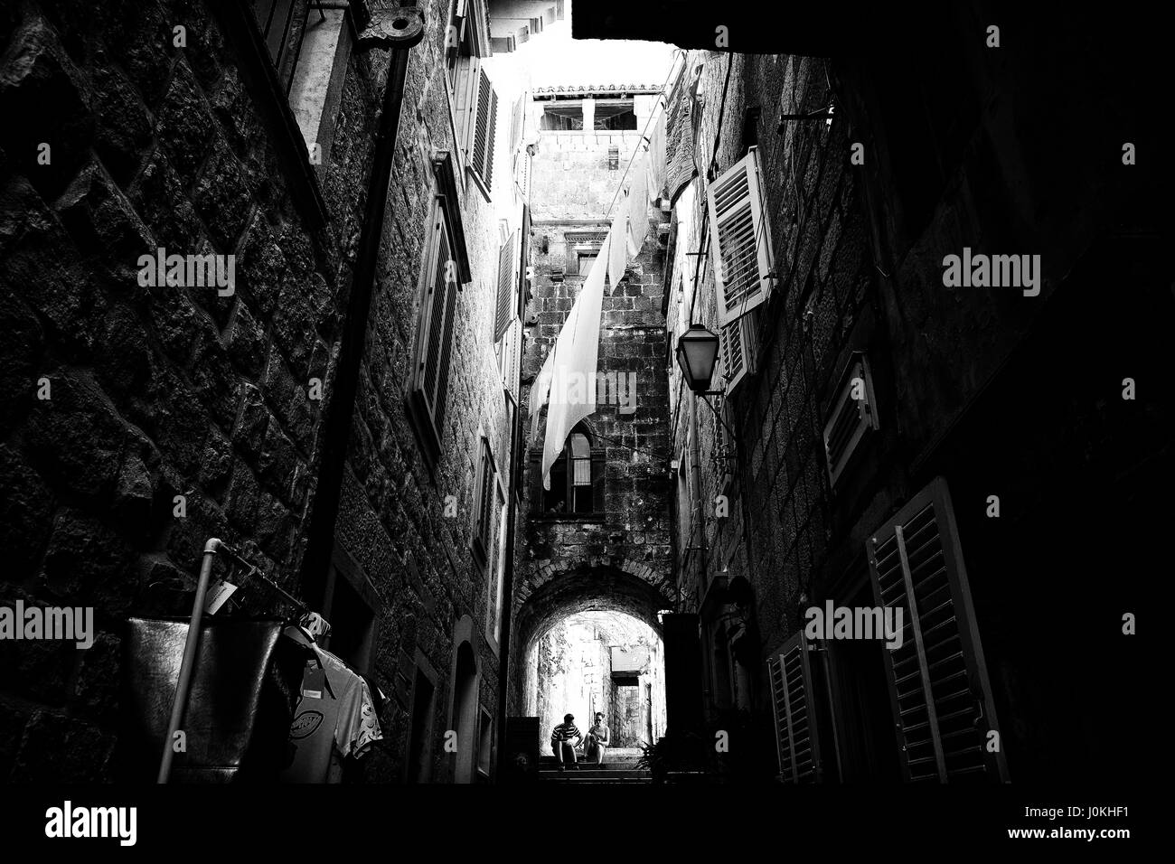 Couple talking under archway, Croatia Stock Photo