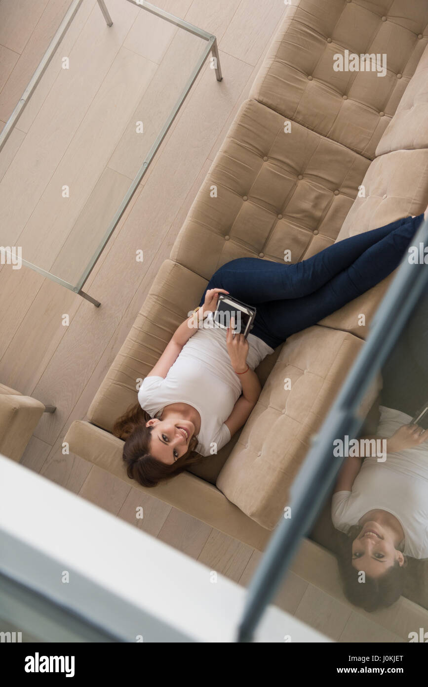 young happy woman on sofa using tablet computer at luxury home Stock ...