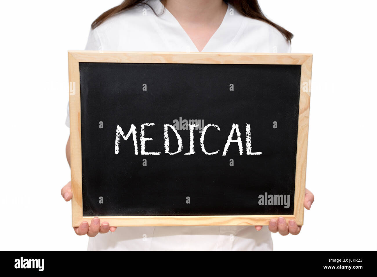 Female nurse holding a slate board with the text Medical written with chalk, isolated on white background. Stock Photo
