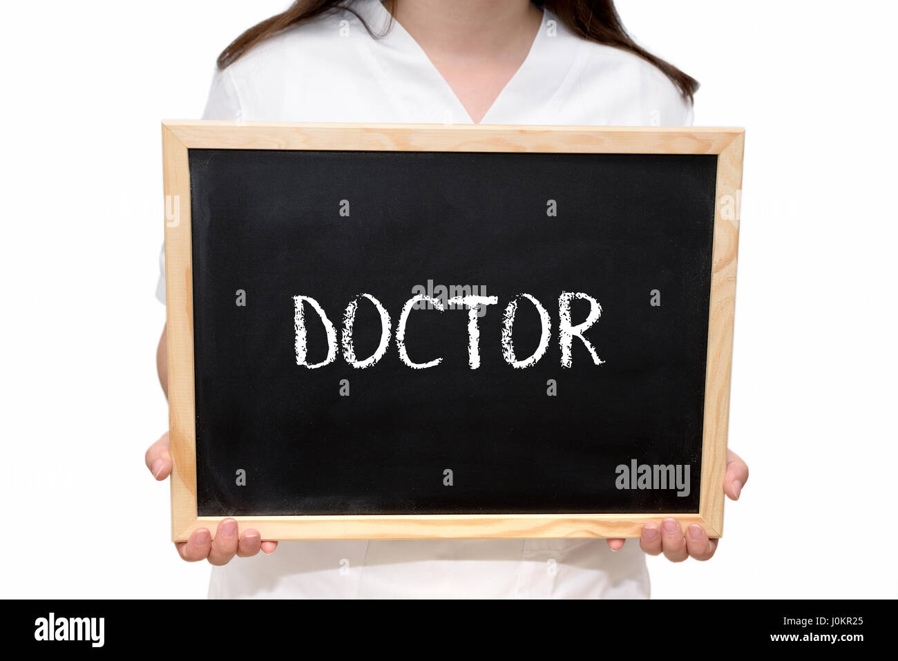 Female nurse holding a slate board with the text Doctor written with chalk, isolated on white background. Stock Photo
