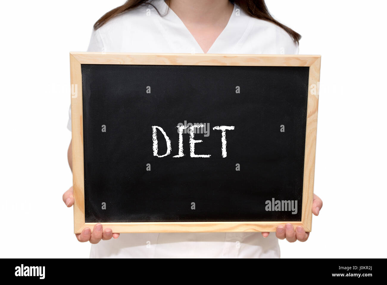 Female nurse holding a slate board with the text Diet written with chalk, isolated on white background. Stock Photo