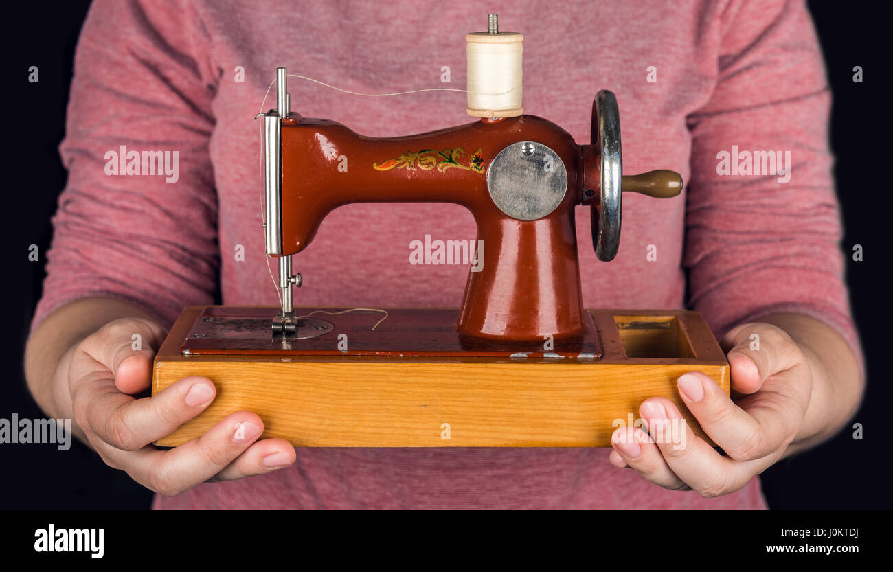 Vintage small sewing machine in woman hand Stock Photo - Alamy