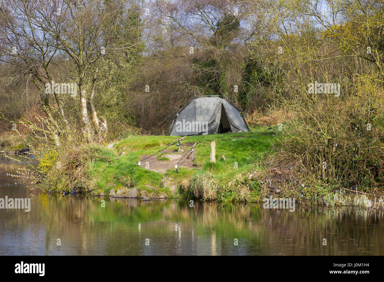 A two man tent pitched on a piece of ground beside the lake at the old lead mines workings in Conlig, County Down in N Ireland on an early spring day. Stock Photo