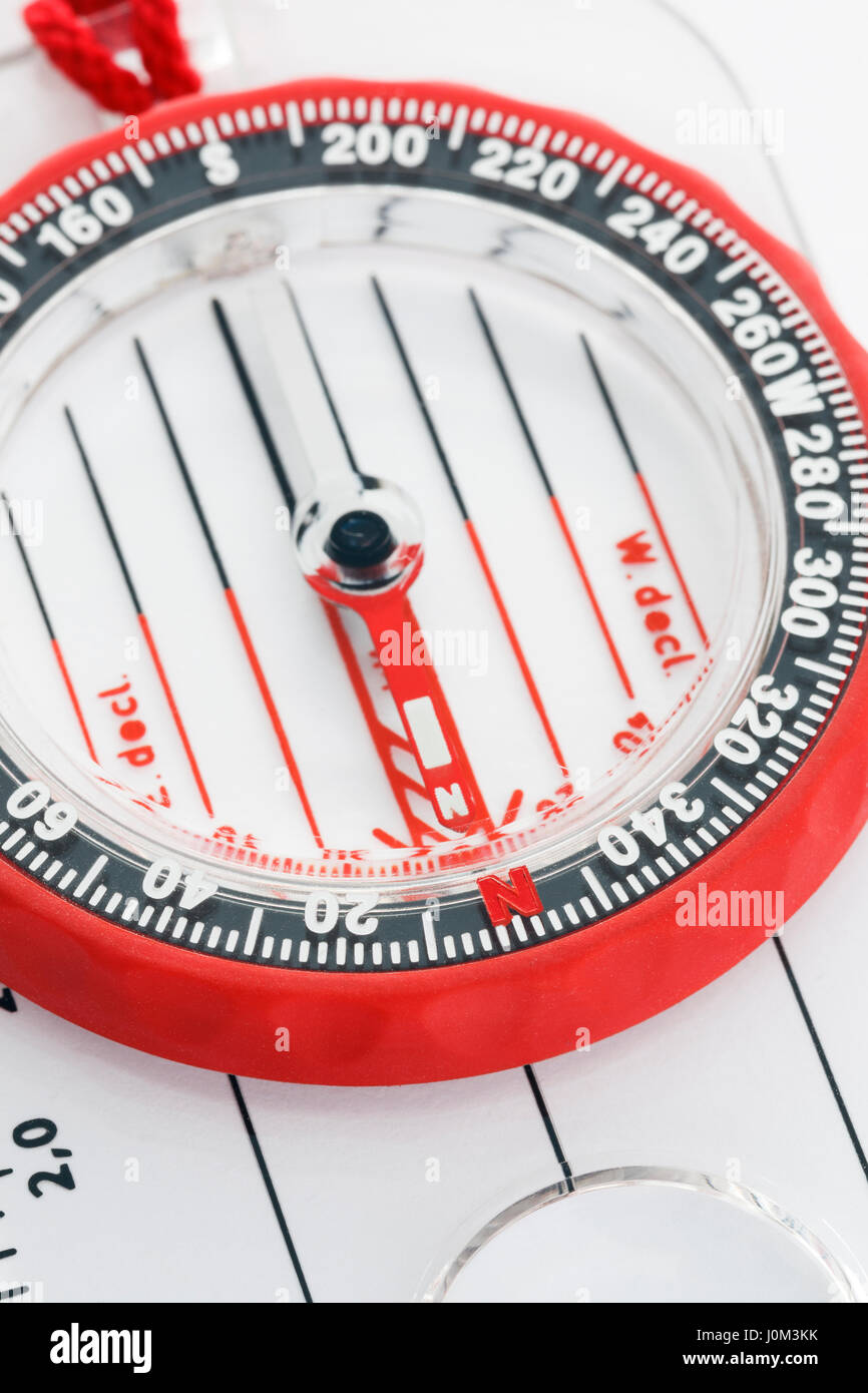 Close-up of a hiking orienteering compass with pointer pointing to magnetic north direction and degrees marked on liquid filled bezel Stock Photo