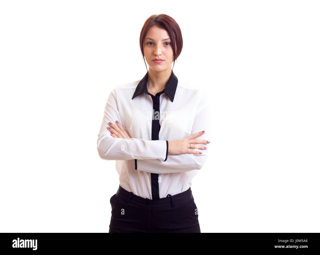 Young serious woman in white shirt and black trousers with ponytail on white background in studio Stock Photo