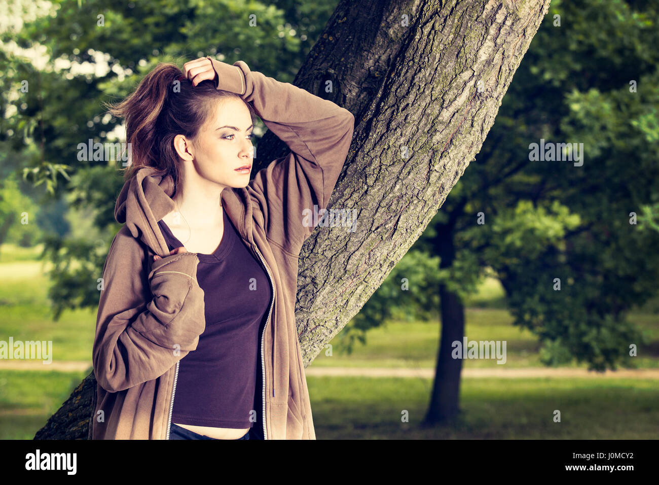 Young woman in sports clothes resting in a park after a morning workout