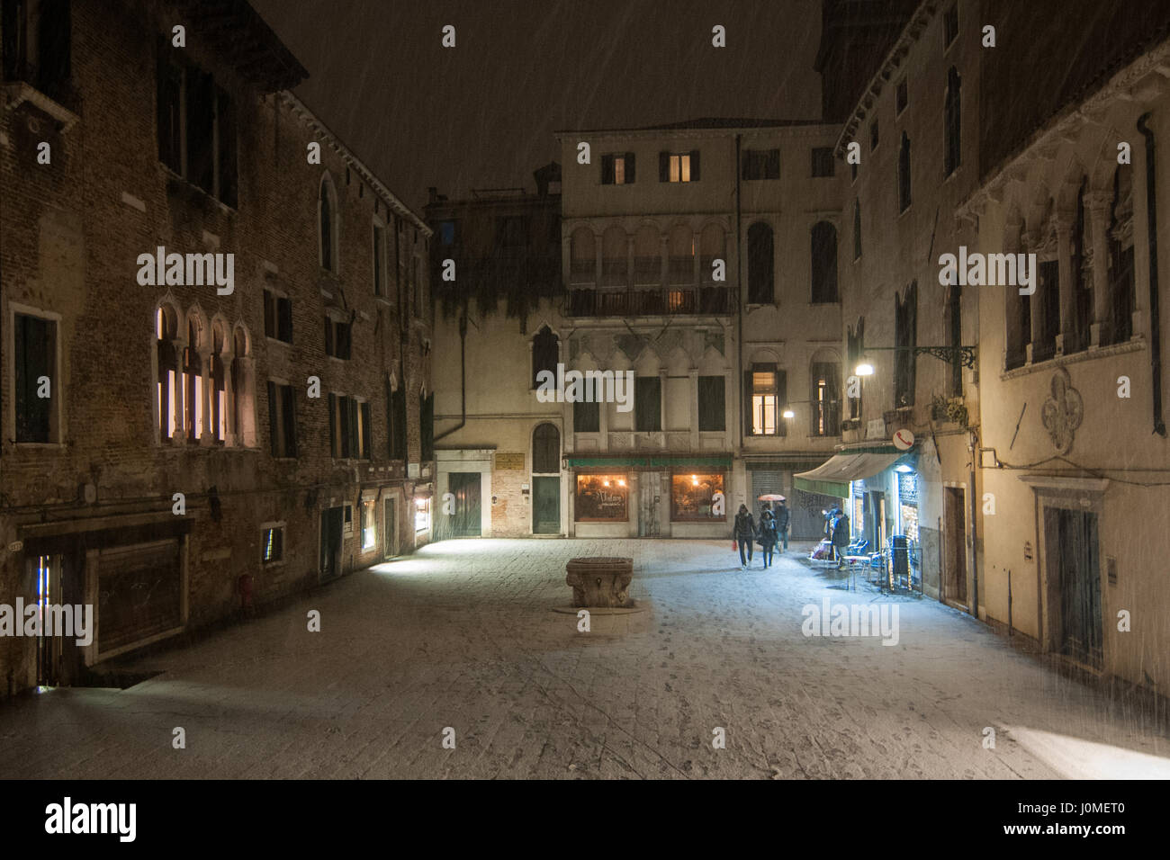 People walk in Santa Maria Mater Domini square during an heavy snow in Venice. Stock Photo